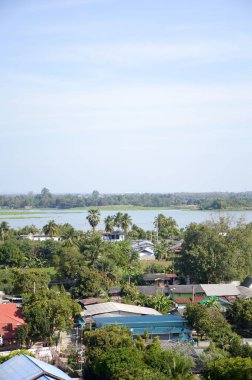Tayland 'ın Kanchanaburi bölgesindeki köy, nehir ve dağın manzarasını görmek için dağdaki tapınağa bakın.