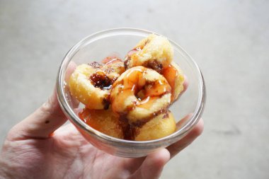 Erkek elinin üzerinde çikolatalı çörek.