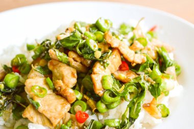 Baharatlı domuz fesleğeni ve kızarmış domuz Tayland usulü yemek.