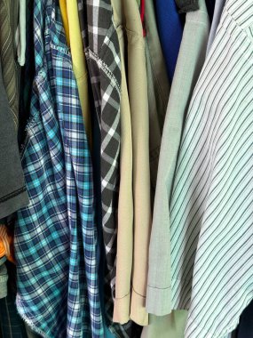 Ahşap askılarda bir yığın elbise. elbiseler ve gömlekler.