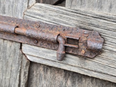 Ahşap arka planda eski paslı asma kilit.