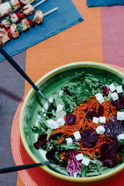 marul salatası, havuç, doğranmış Yunan peyniri, pancar ve kiraz domatesleri porselen salata kasesinde.