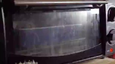 Bakır renkli tavada sebzeli makarna ve balık pişirmek ahşap çatalla, sağlıklı besinlerle karıştırılır.