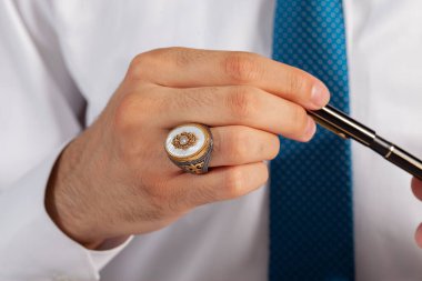 Yüzük ve aksesuarlı, beyaz elbiseli, bakımlı bir adamla yaratıcı fotoğraf çekimi.