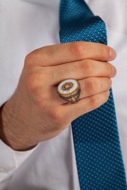 Yüzük ve aksesuarlı, beyaz elbiseli, bakımlı bir adamla yaratıcı fotoğraf çekimi.