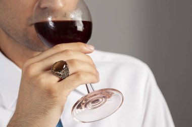 Yüzük ve aksesuarlı, beyaz elbiseli, bakımlı bir adamla yaratıcı fotoğraf çekimi.