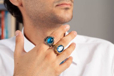 Yüzük ve aksesuarlı, beyaz elbiseli, bakımlı bir adamla yaratıcı fotoğraf çekimi.