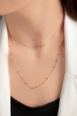 Tırnakları bakımlı olan bayan, çok güzel kolyeler veriyor. Gümüş, elmas, altın kolyeler.