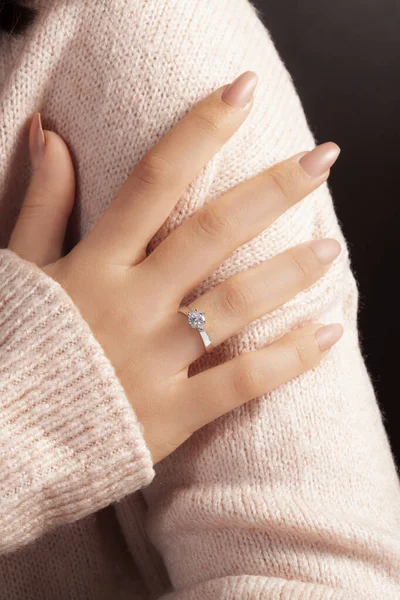 diamond ring in the hand of the girl with well-groomed hands. online sales image