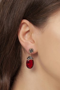 Bakımlı modelin kulağında doğal taştan küpeler var. Çevrimiçi satış küpe resmi