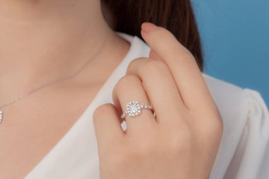 İyi giyimli ve zarif bayanın parmağına takılan gümüş elmas yüzük.