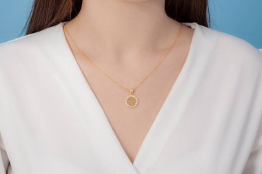 Altın ve gümüş kolye bakımlı, zarif, beyaz giysili bayana