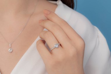 İyi giyimli ve zarif bayanın parmağına takılan gümüş elmas yüzük.