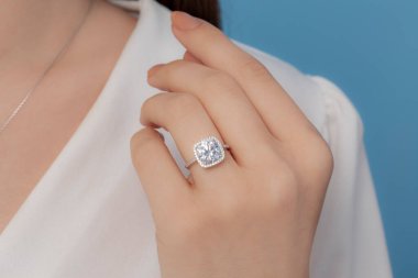 İyi giyimli ve zarif bayanın parmağına takılan gümüş elmas yüzük.