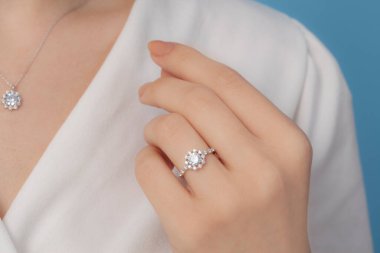 İyi giyimli ve zarif bayanın parmağına takılan gümüş elmas yüzük.