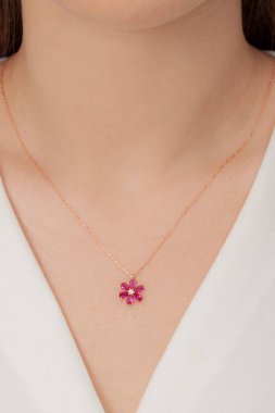 Tırnakları bakımlı olan bayan, çok güzel kolyeler veriyor. Gümüş, elmas, altın kolyeler.