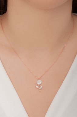 Tırnakları bakımlı olan bayan, çok güzel kolyeler veriyor. Gümüş, elmas, altın kolyeler.