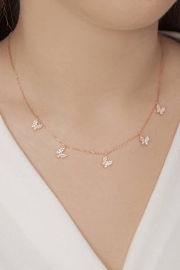 Tırnakları bakımlı olan bayan, çok güzel kolyeler veriyor. Gümüş, elmas, altın kolyeler.