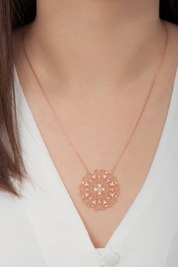 Çok güzel kolyeler ve bakımlı tırnaklar sunar. Parlak kolyesi olan güzel genç bir kadın..