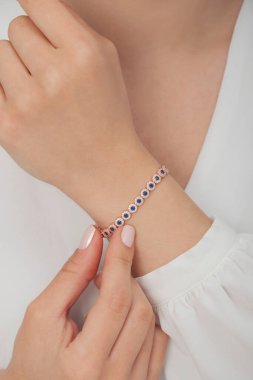 Tırnakları bakımlı bayan güzel bilezikler sergiliyor..