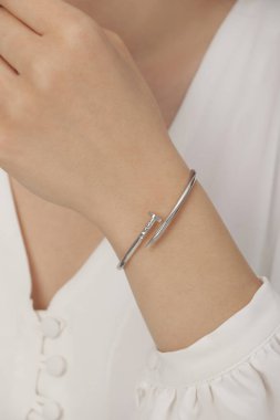 Tırnakları bakımlı bayan güzel bilezikler sergiliyor..