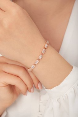 Tırnakları bakımlı bayan güzel bilezikler sergiliyor..