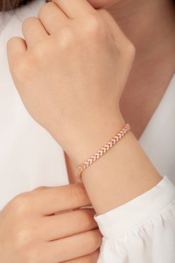 Tırnakları bakımlı bayan güzel bilezikler sergiliyor..