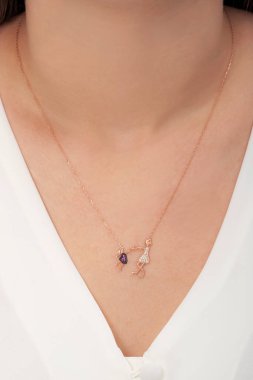 Tırnakları bakımlı olan bayan, çok güzel kolyeler veriyor. Gümüş, elmas, altın kolyeler.