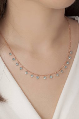 Tırnakları bakımlı olan bayan, çok güzel kolyeler veriyor. Gümüş, elmas, altın kolyeler.