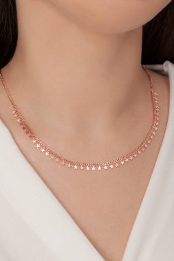 Tırnakları bakımlı olan bayan, çok güzel kolyeler veriyor. Gümüş, elmas, altın kolyeler.