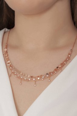 Tırnakları bakımlı olan bayan, çok güzel kolyeler veriyor. Gümüş, elmas, altın kolyeler.