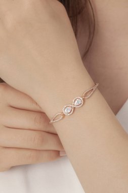 Tırnakları bakımlı olan kadın güzel bilezikler sergiliyor. Bileklik resimleri e-ticaret satışlarında kullanılabilir..