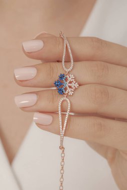 Tırnakları bakımlı olan kadın güzel bilezikler sergiliyor. Bileklik resimleri e-ticaret satışlarında kullanılabilir..