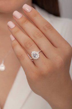 Kadın parmağında zarif gümüş bir yüzük. Çevrimiçi satış için yüzük, bakımlı ellerde parlıyor.