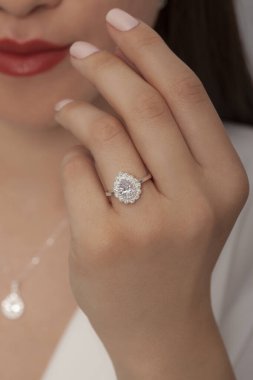 Kadın parmağında zarif gümüş bir yüzük. Çevrimiçi satış için yüzük, bakımlı ellerde parlıyor.