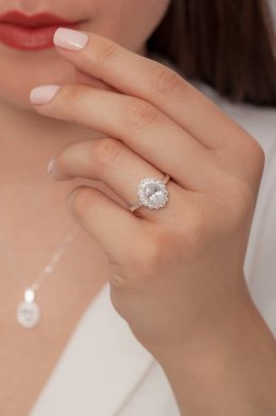 Kadın parmağında zarif gümüş bir yüzük. Çevrimiçi satış için yüzük, bakımlı ellerde parlıyor.