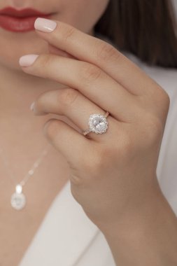 Kadın parmağında zarif gümüş bir yüzük. Çevrimiçi satış için yüzük, bakımlı ellerde parlıyor.