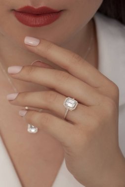 Kadın parmağında zarif gümüş bir yüzük. Çevrimiçi satış için yüzük, bakımlı ellerde parlıyor.