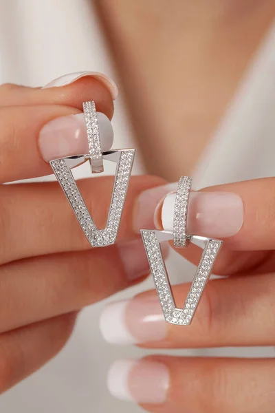 Manikürlü Bakımlı Ellerinde Gümüş Küpeler Gösteren Bir Kadın Çevrimiçi Satışlar — Stok fotoğraf