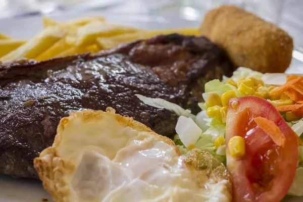 Steak with fried egg and salad — Stock Photo, Image