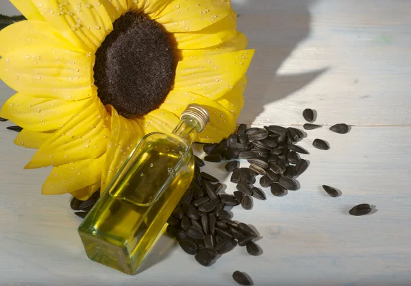 Bottle of oil and sunflower seeds — Stock Photo, Image