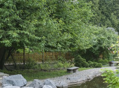 bahçeye bir gölet ve çiçekli ağaçlar