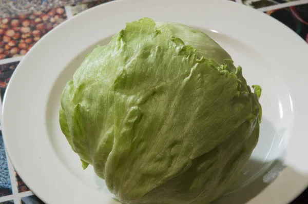 Yakın plan: beyaz tabakta bir somun buzdağı marulu