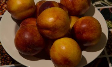 Yakın plan: beyaz bir tabakta yedi nektarin.