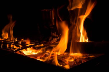 Yakın plan: Açık hava ızgara kutusunda bir Ibrik 'li barbekü için alevler 