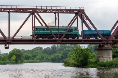 Yük treni nehir üzerindeki bir demiryolu köprüsüne biner..