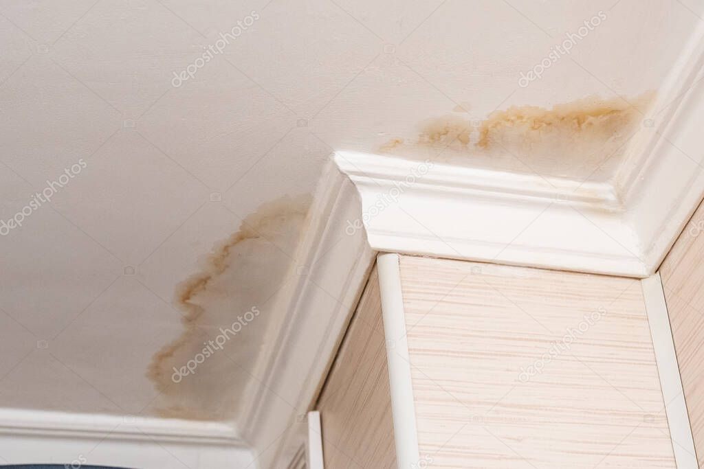 Neighbors have a water leak, water-damaged ceiling, close-up of a stain on the ceiling.