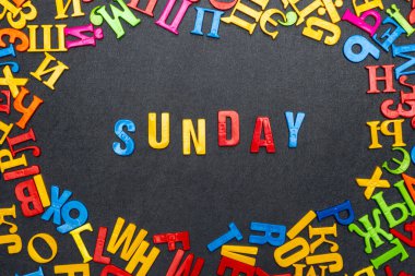 Siyah arkaplandaki parlak renkli harflerin Pazar kelimesi.