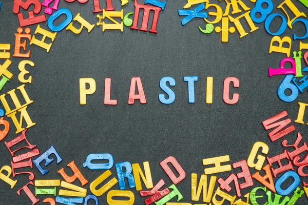 Plastic, word from bright color letters on black background.
