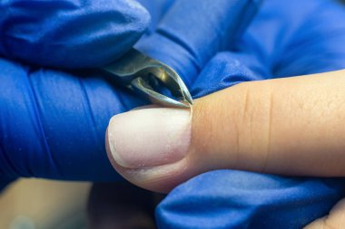 Manikürcü, meme uçlarının yardımıyla müşterinin parmağındaki ölü deriyi temizler..